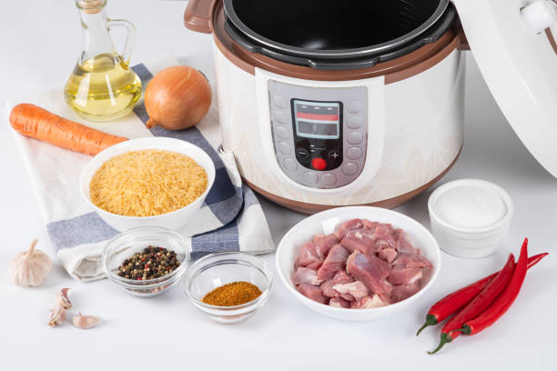 istock Modern multi cooker with prepared ingredients for cooking pilaf in kitchen on a table. Cooking pilau with meat in multicooker. Eastern cuisine. 1834935190