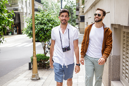 Mid-shot of two young men sightseeing in fancy Buenos Aires neighborhood, Argentina