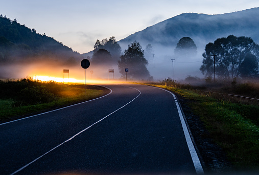 Empty road in a mountain valley. Forgotten and surrounded by clouds of fog