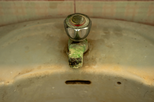 limestone accumulated faucet or water tab, efflorescence stain on old and dirty water tap on the sink in toilet