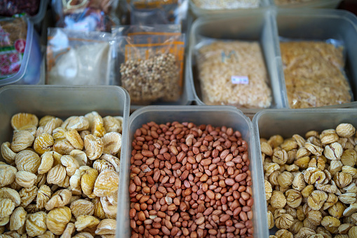 From a high angle perspective, an assortment of dried nuts is showcased on a market stall, providing a tempting display of variety for potential buyers.