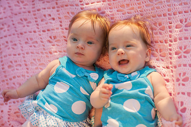 istock Sweet little  twins lying on a pink blanket. 183497256