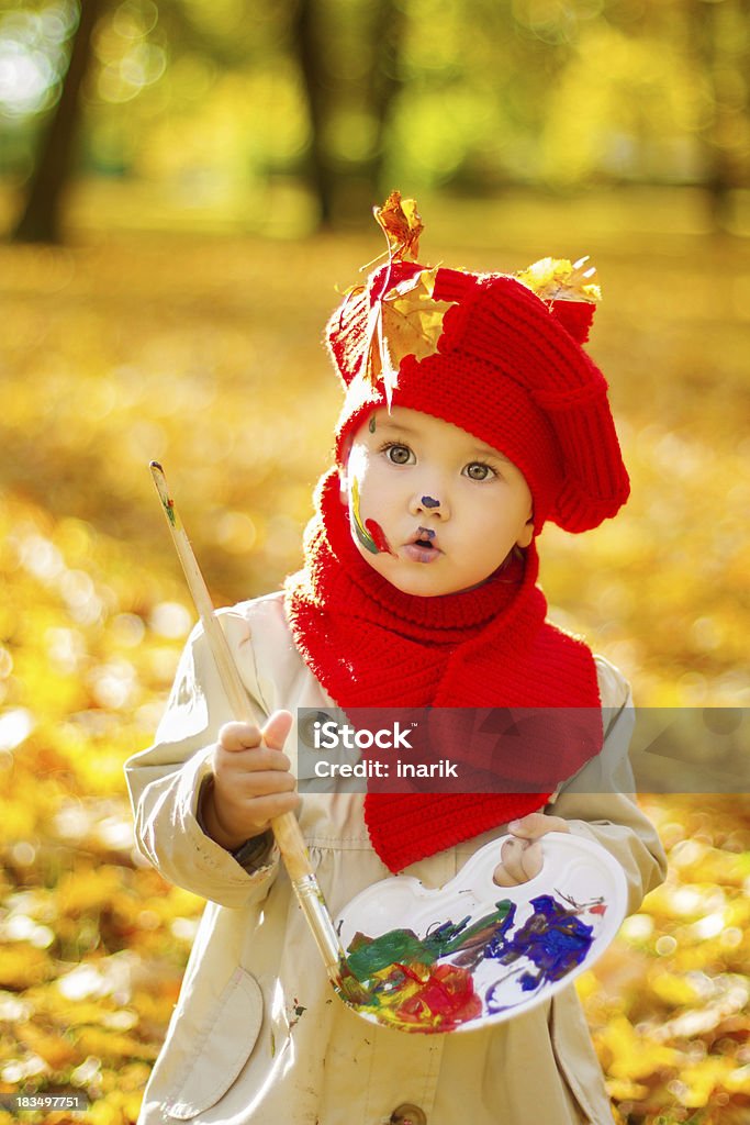子供の絵画黄秋の公園。クリエイティブなお子様に赤の帽子 - 1人のロイヤリティフリーストックフォト