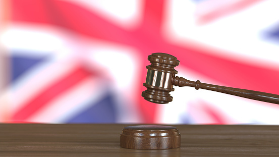 3D render - Judge's gavel against the background of the UK flag.