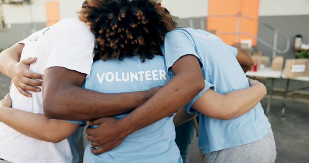 Community, charity and a volunteer group in a huddle together for teamwork, unity or solidarity. Recycle, team building and sustainability with ngo people hugging in support of an earth day project la comunidad, la caridad y un grupo de voluntarios se agrupan para el trabajo en equipo, la unidad o la solidaridad. reciclaje, trabajo en equipo y sostenibilidad con personas de ong que se abrazan en apoyo de un proyecto del día de la tierra