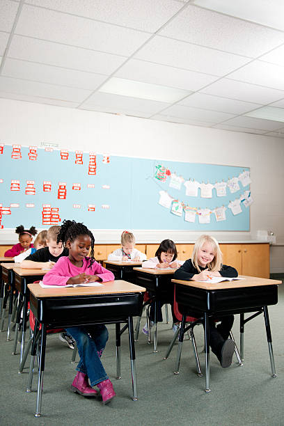 First grade First graders in a classroom  first grade classroom stock pictures, royalty-free photos & images