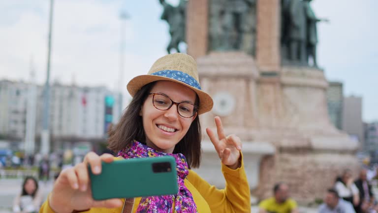 Young Woman Taking Selfies In Front Of A Republic Monument On A Taksim Square Of Istanbul