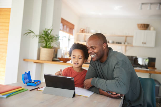 istock Dad and little son smiling while doing homework together on a tablet 1835067673