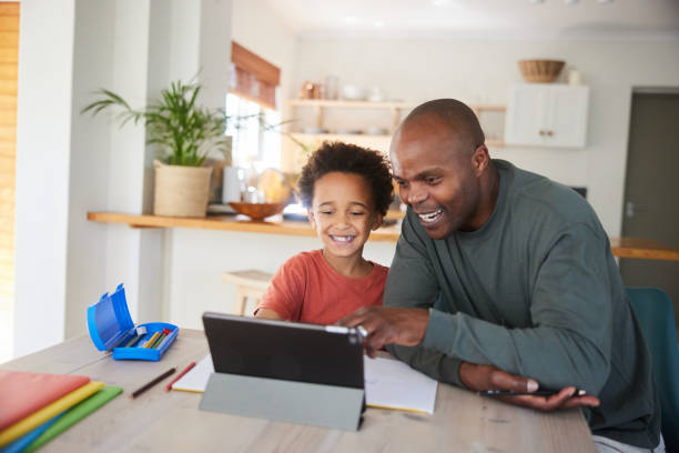 istock Dad and little son laughing while doing homework together on a tablet 1835068722