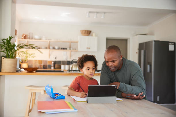 istock Dad helping his little boy do his homework at a kitchen table 1835069303