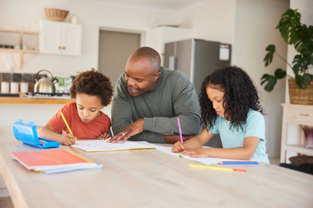 istock Dad helping his two children with their homework at a kitchen table 1835070360
