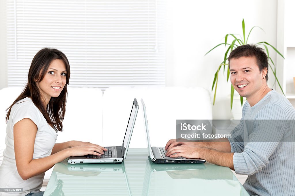 Jovem e mulher a trabalhar no computador portátil em superfície de pavilhão - Royalty-free Adolescente Foto de stock