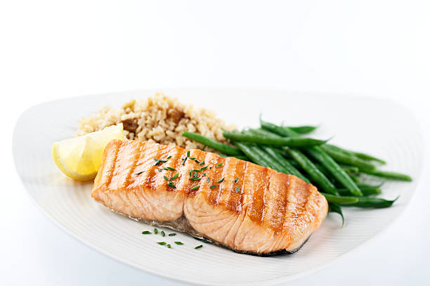 Healthy Salmon Dinner SEVERAL MORE IN THIS SERIES. Salmon steak with green beans and brown rice pilaf for a healthy dinner.  Shallow DOF. grilled salmon stock pictures, royalty-free photos & images