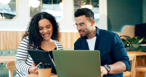 istock People, laptop and tablet at cafe for teamwork, planning and collaboration in remote work project or business startup. Happy woman, man or freelancer with client on digital technology at coffee shop 1835075871