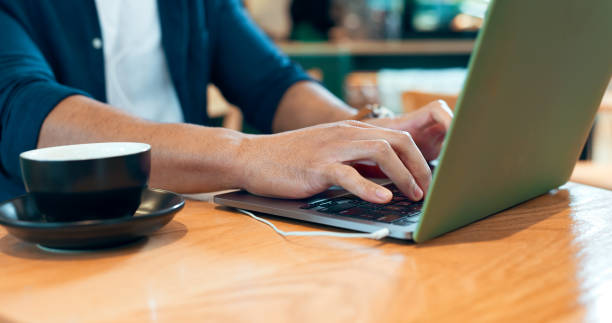 istock Hands typing, laptop and coffee shop for remote work, online research and planning for marketing project. Person, customer or freelancer at cafe or restaurant with internet, computer and research 1835075882