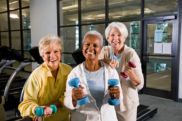 multiraciale femmes seniors gardez la forme dans la salle de sport musculation handweig - staying fit photos et images de collection