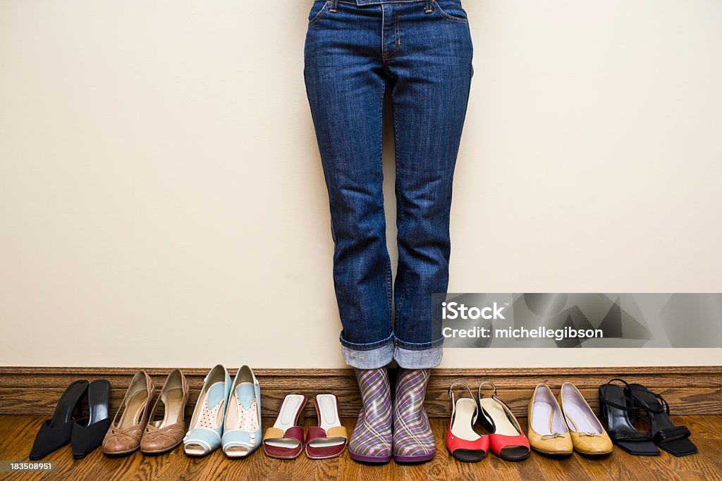 Frau mit Regen Stiefel neben vielen Schuh - Lizenzfrei Anprobieren Stock-Foto