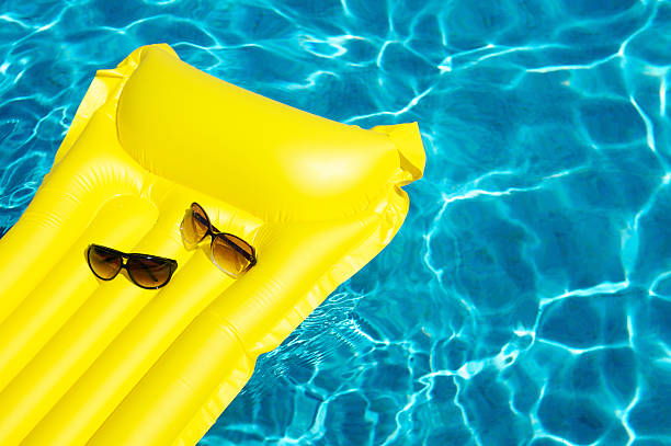 istock His and Hers Sunglasses Float on Yellow Pool Raft 183510336