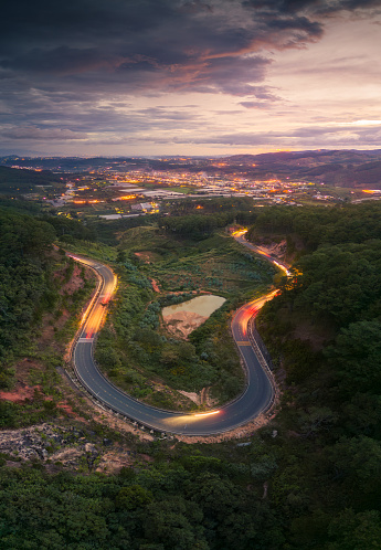 Aerial view of Ta Nung Pass in Da Lat City, Vietnam in the sunset. The winding road in the distance is Dalat city, Vietnam. Long exposure.