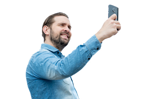 Latino Caucasian man in jean shirt taking a selfie.