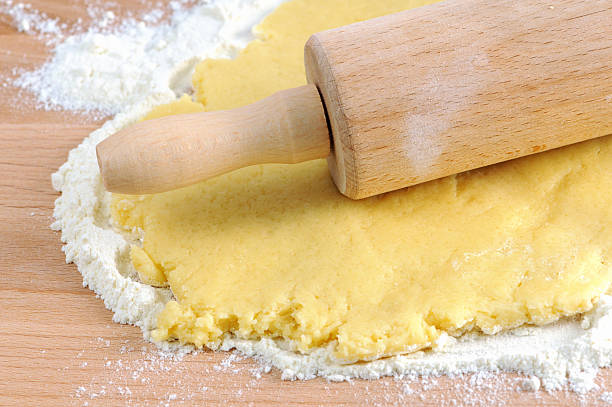 wood rolling pin forming cookie dough stock photo