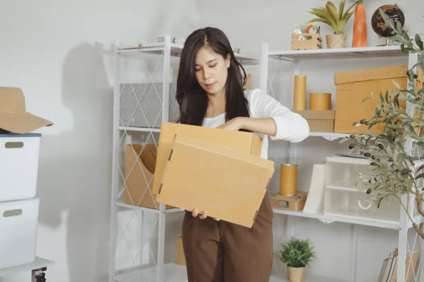 istock A young woman is putting things into boxes to pack. 1835163242