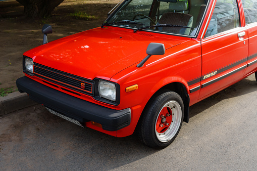 Details - hood mirrors of Toyota Starlet XL (second 2 generation facelift 60 Series) 5 doors hatchback in red color with  is parked in Saint-Petersburg, Russia, 19.08.2019