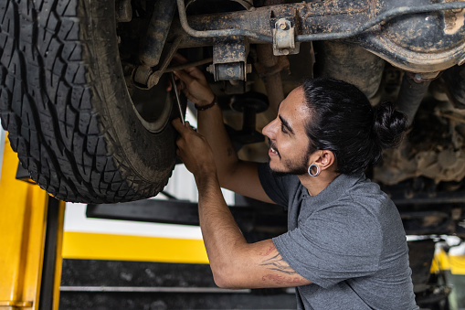 Latin man servicing car in mechanic's shop