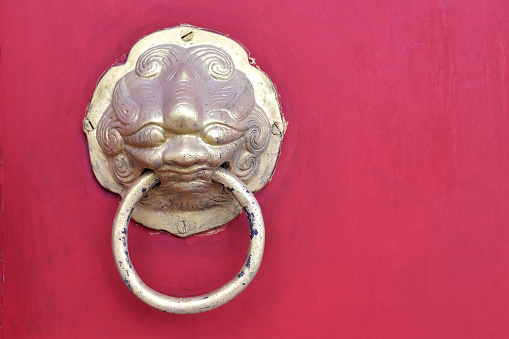grunge gilded steel door knocker for asian antique style home decor, close-up with copy space