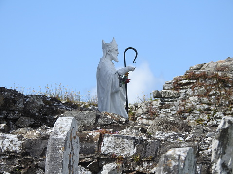 The ancient statue is inside the walled cemetery on Slane Hill and there are wild flowers growing on top of the wall. As far as I can gather, the monument to St. Patrick was made by a long-dead local sculptor many years ago.