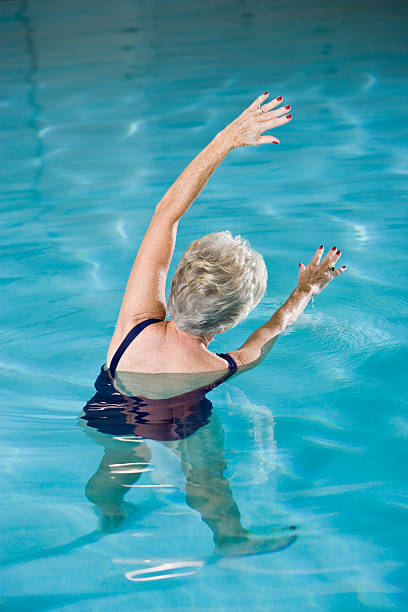istock Active senior woman exercising in swimming pool 183519475