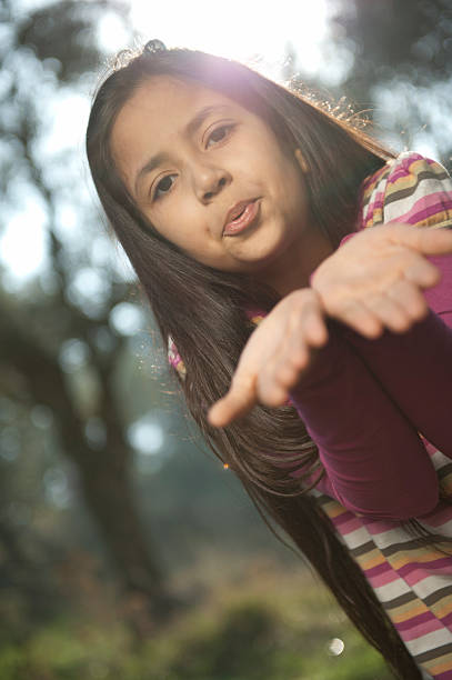 pretty little girl playing on a rock at the water's edge