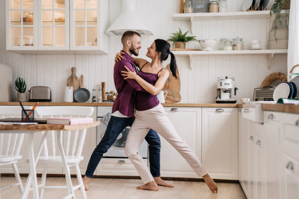 istock Bearded young man dancing with girlfriend at kitchen smiling learning wedding dance. Happy couple celebrating new apartment. Dancers at home. 1835221253