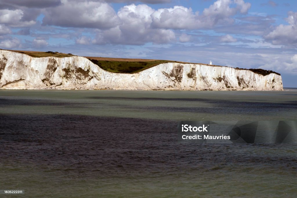 Beautiful white cliffs of the English coast Landscape view of white cliffs of Dover from the sea,with a beautiful cloudy sky and sun Beach Stock Photo