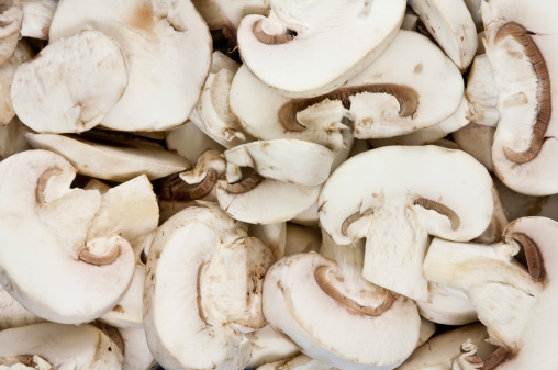 Full frame background/texture of white sliced mushrooms.