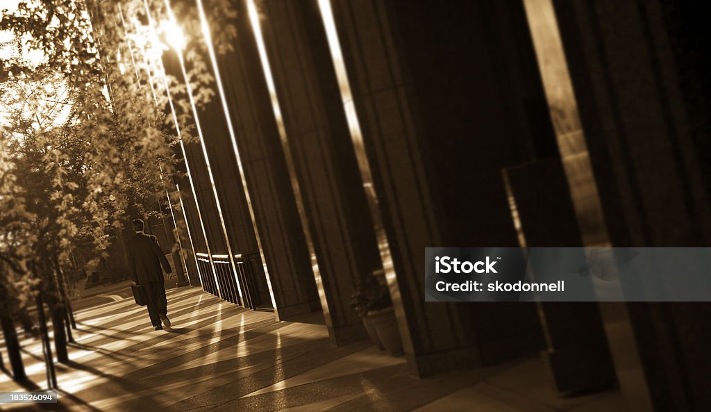 Businessman Walking Downtown This is a sepia toned photograph of a businessman walking in downtown Phoenix. The focus falls off on the left and right allowing for a lot of nice space for copy on the right side.Click on the links below to view lightboxes. Arizona Stock Photo