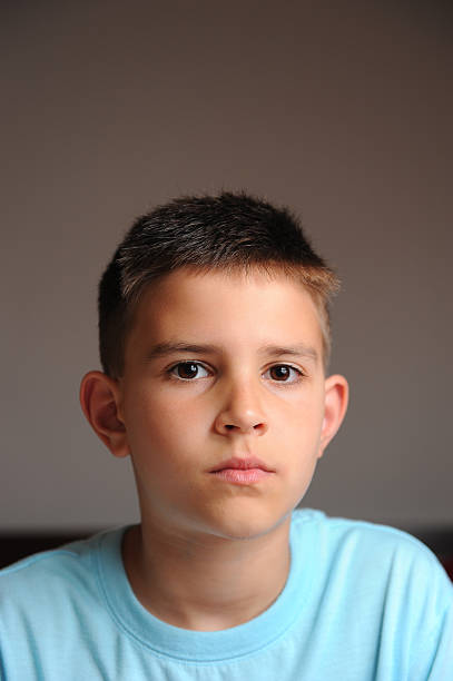 Clean cut young boy looking at the camera Clean cut young 9 year old boy looking at the camera with a serious look. crew cut stock pictures, royalty-free photos & images
