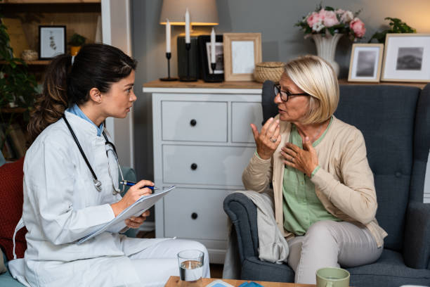 young woman nurse doctor gp holding stethoscope examining old senior 60s grandma patient check heartbeat at home-care checkup medical visit at home hospital, older people cardiology healthcare concept - pressure gauge audio imagens e fotografias de stock