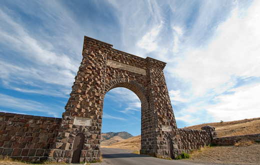Roosevelt Arch under a dramatic sky, north entrance to Yellowstone National Park. Gardiner, Montana.