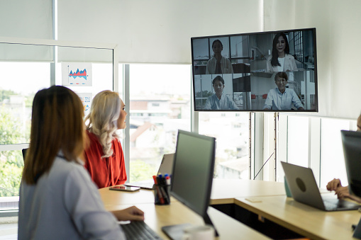 Online video conference call on tv screen in meeting room office in Thailand