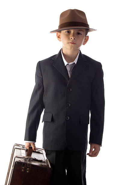 istock Little boy in old fashioned suit holding suitcase 183530396