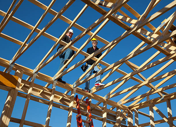 istock Building Construction; Two Workers Atop Roof Trusses 183531819