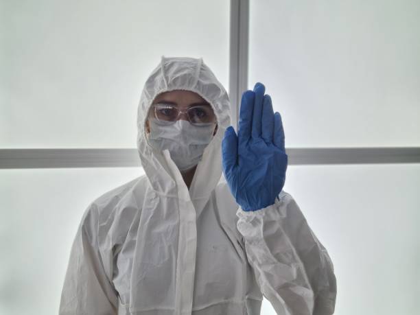 istock Doctor in protective suit makes stop sign with hand 1835320955