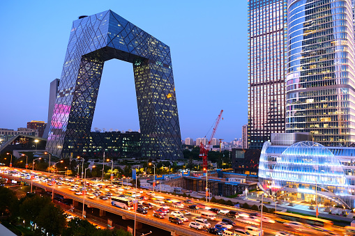 View of the busy elevated road at dusk by the CCTV Headquarters, a 51-floor, 234 mt skyscraper formed out of a pair of conjoined towers in the Beijing Central Business District and serves as the headquarters for China Central Television (CCTV).