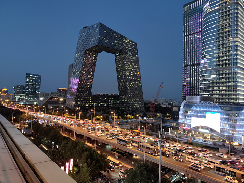 View of the busy elevated road at night by the CCTV Headquarters, a 51-floor, 234 mt skyscraper formed out of a pair of conjoined towers in the Beijing Central Business District and serves as the headquarters for China Central Television (CCTV).