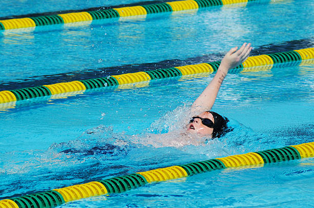 istock Young Boy Male Athlete Backstroke Swimming Racing in Pool 183533252