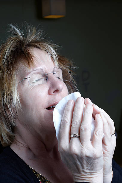 istock Mature woman sneezing into tissue 183533469