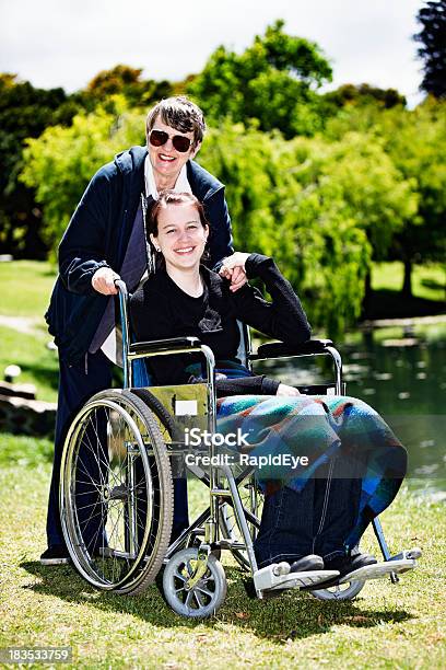 Teenagermädchen Im Rollstuhl Mit Älteren Pflegekraft Halten Hände Lächeln Stockfoto und mehr Bilder von 60-69 Jahre
