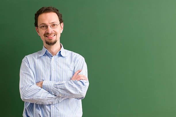 istock teacher with glasses smiling at blackboard 183534274