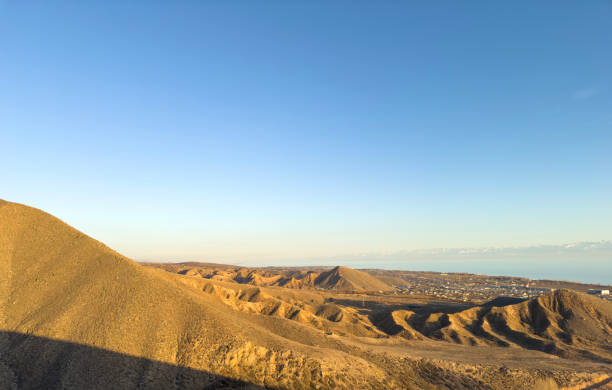A breathtaking panorama unfolds, revealing lush green hills nestled within the mountainous expanse.